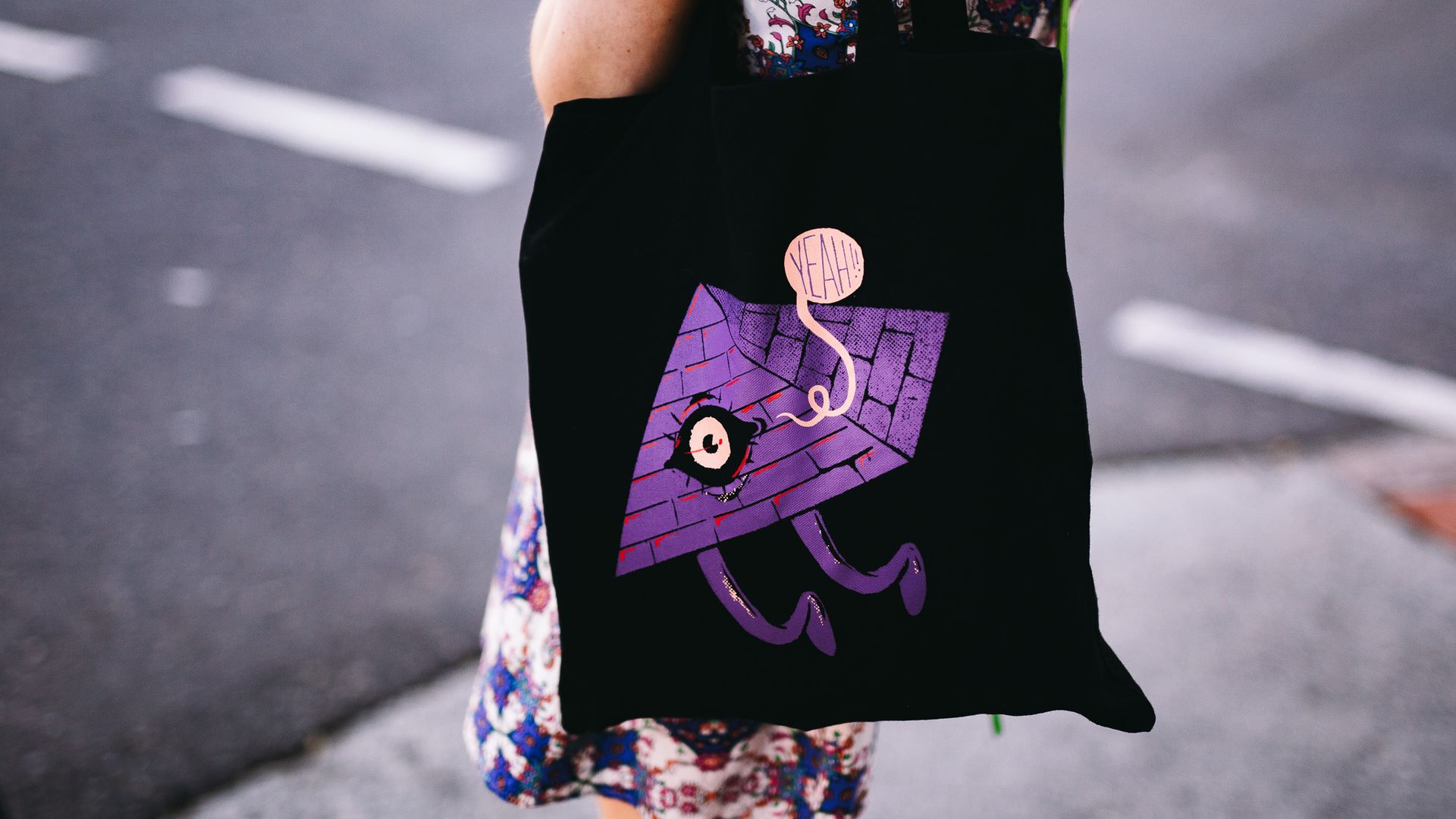 A photograph of a woman wearing a Bigsound branded tote bag. 